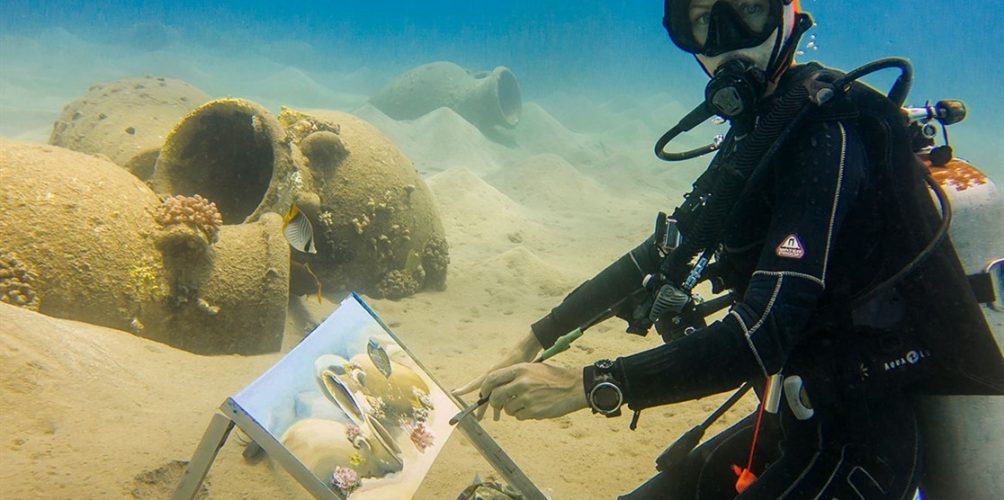 جذبت الآلاف في معارضها.. شابة ترسم لوحاتها تحت الماء